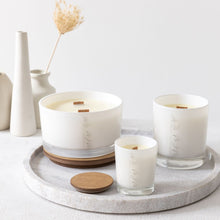 Load image into Gallery viewer, A picture of 3 different sized candles, which shows the difference between the 50cl, 30cl &amp; 9cl options. All of which have wooden wicks and are in white glass vessels with the MJM Home Fragrance logo
