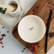 Load image into Gallery viewer, A birds eye view picture of a 30cl candle with a wooden wick surrounded by ingredients depicting vanilla and pink peppercorns
